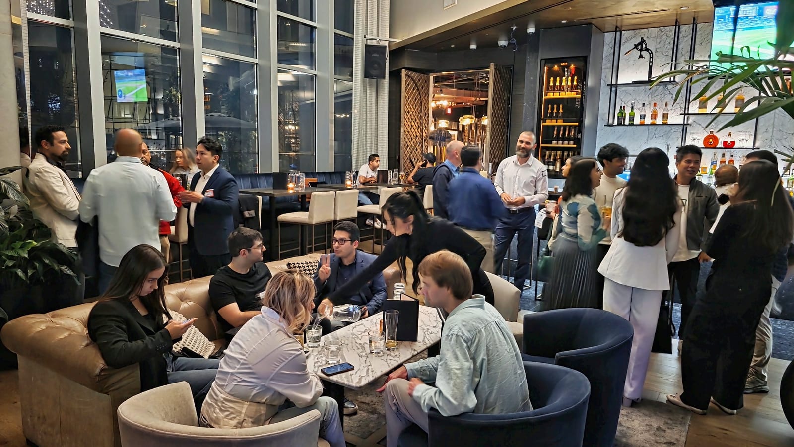 Guests talking in small groups across the lounge at Karma Lounge during a Get2Gether business networking night in downtown Vancouver