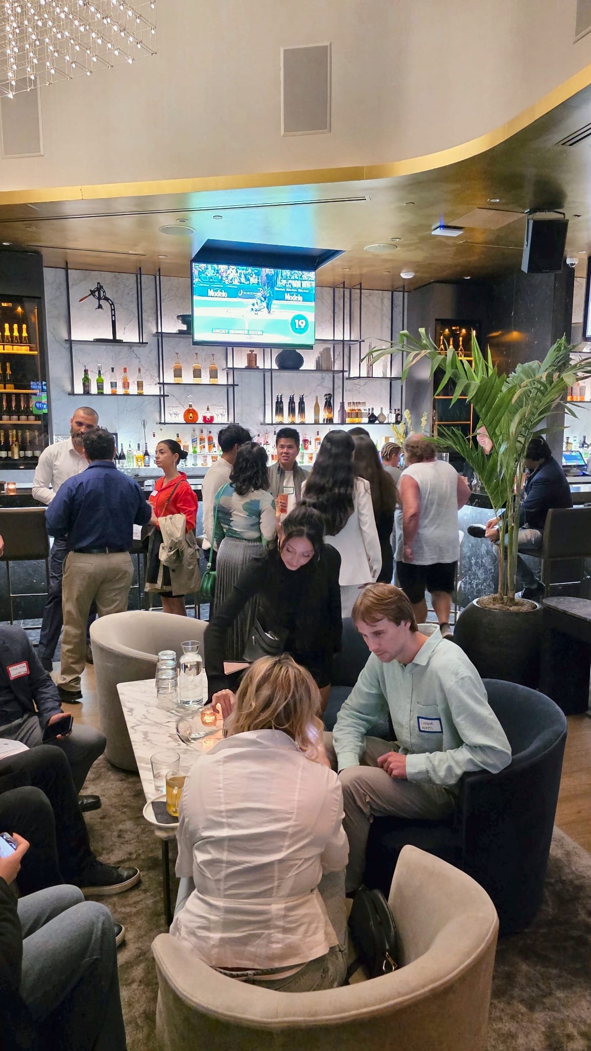 Professionals seated around lounge tables in conversation at the Get2Gether networking night