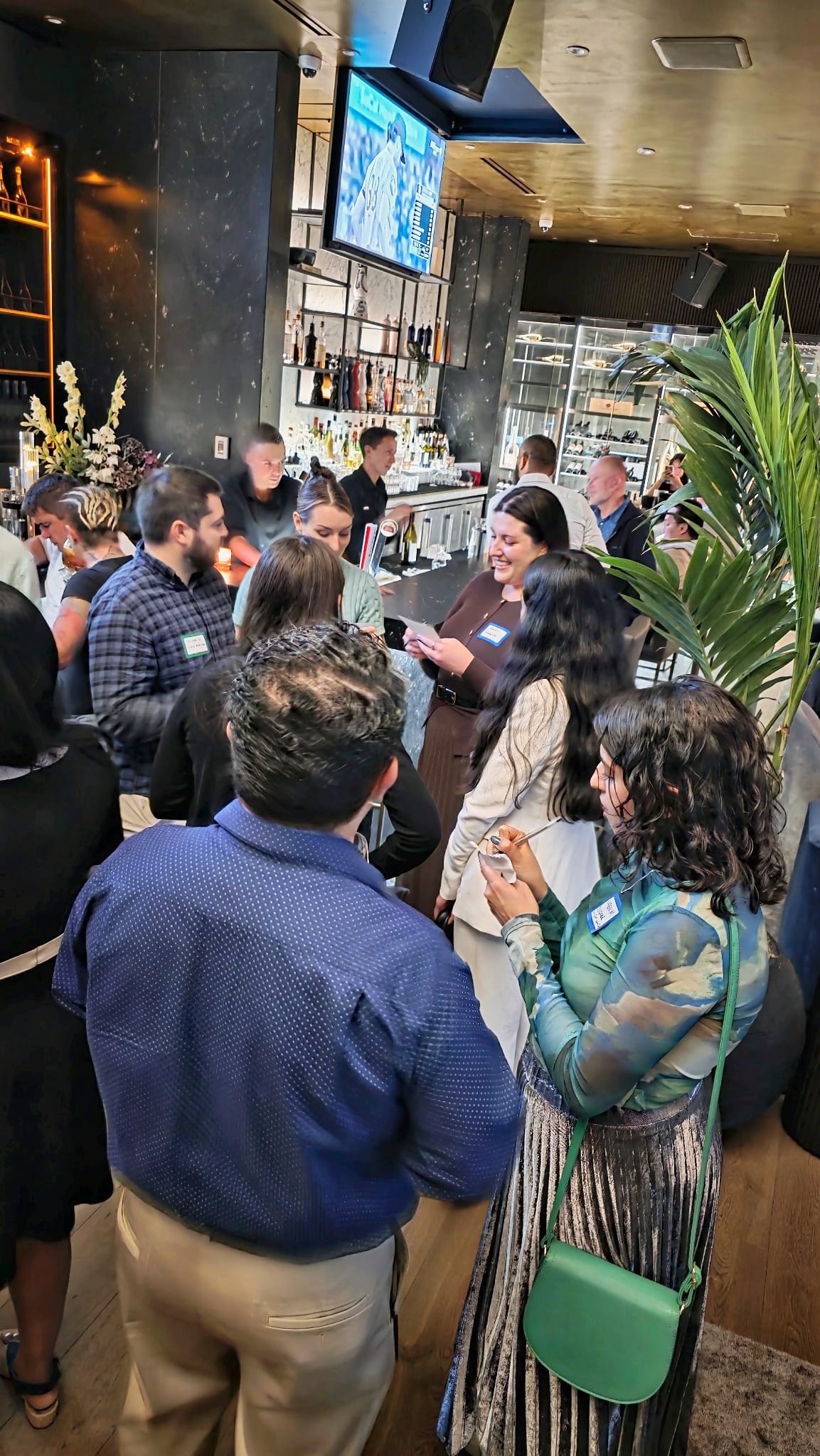 A standing group of guests, name badges on, talking at the Get2Gether Vancouver networking night