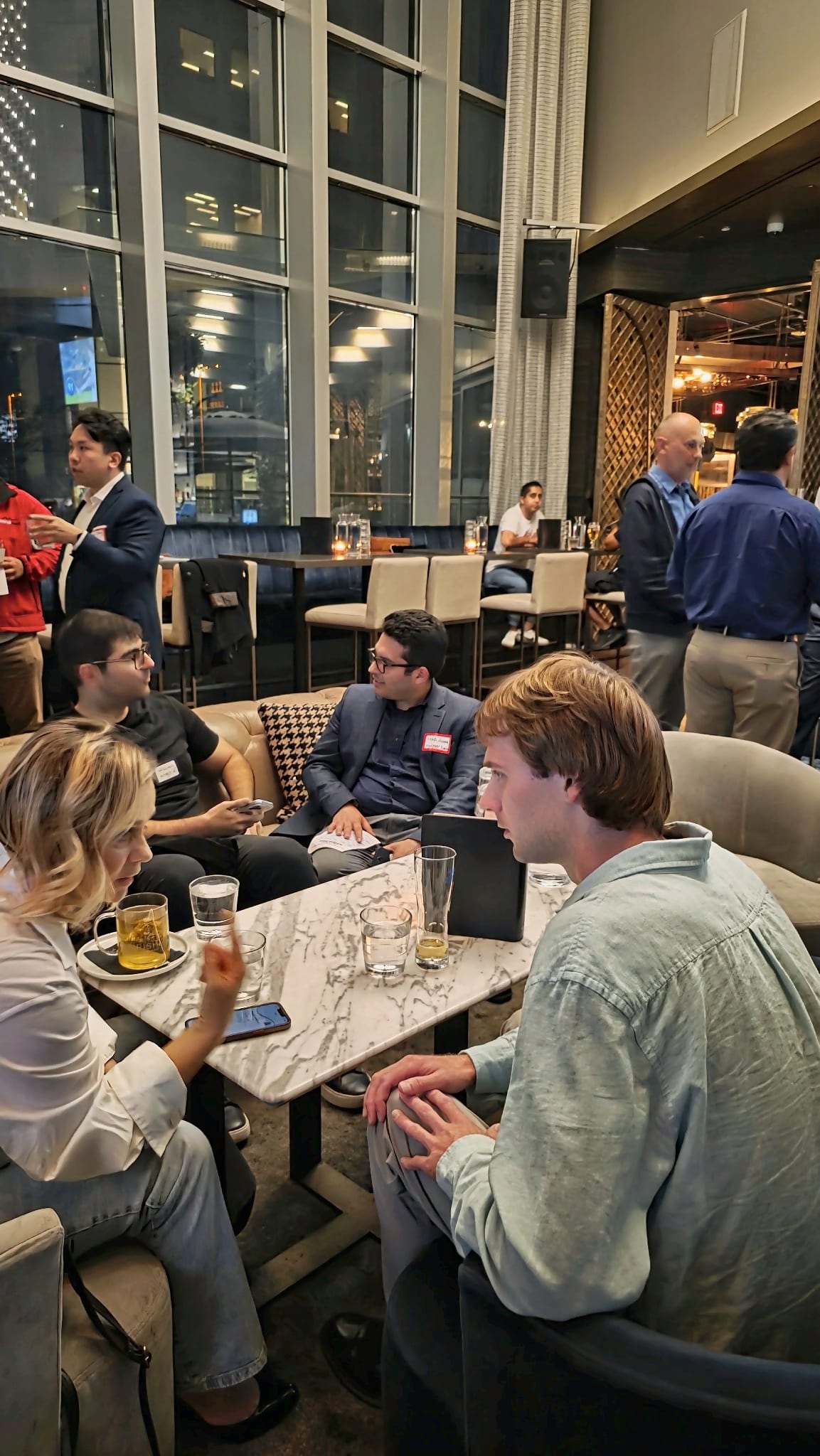 Two guests comparing notes over drinks at a lounge table