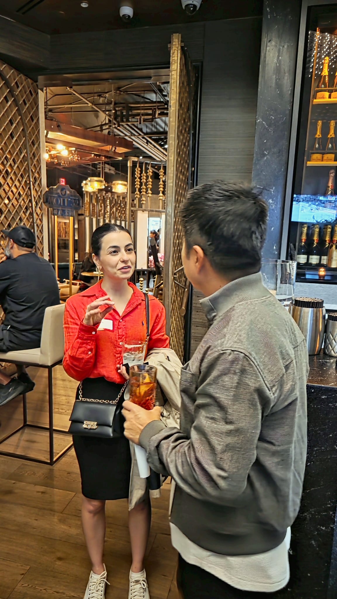 Two guests in conversation beside the bar at Karma Lounge