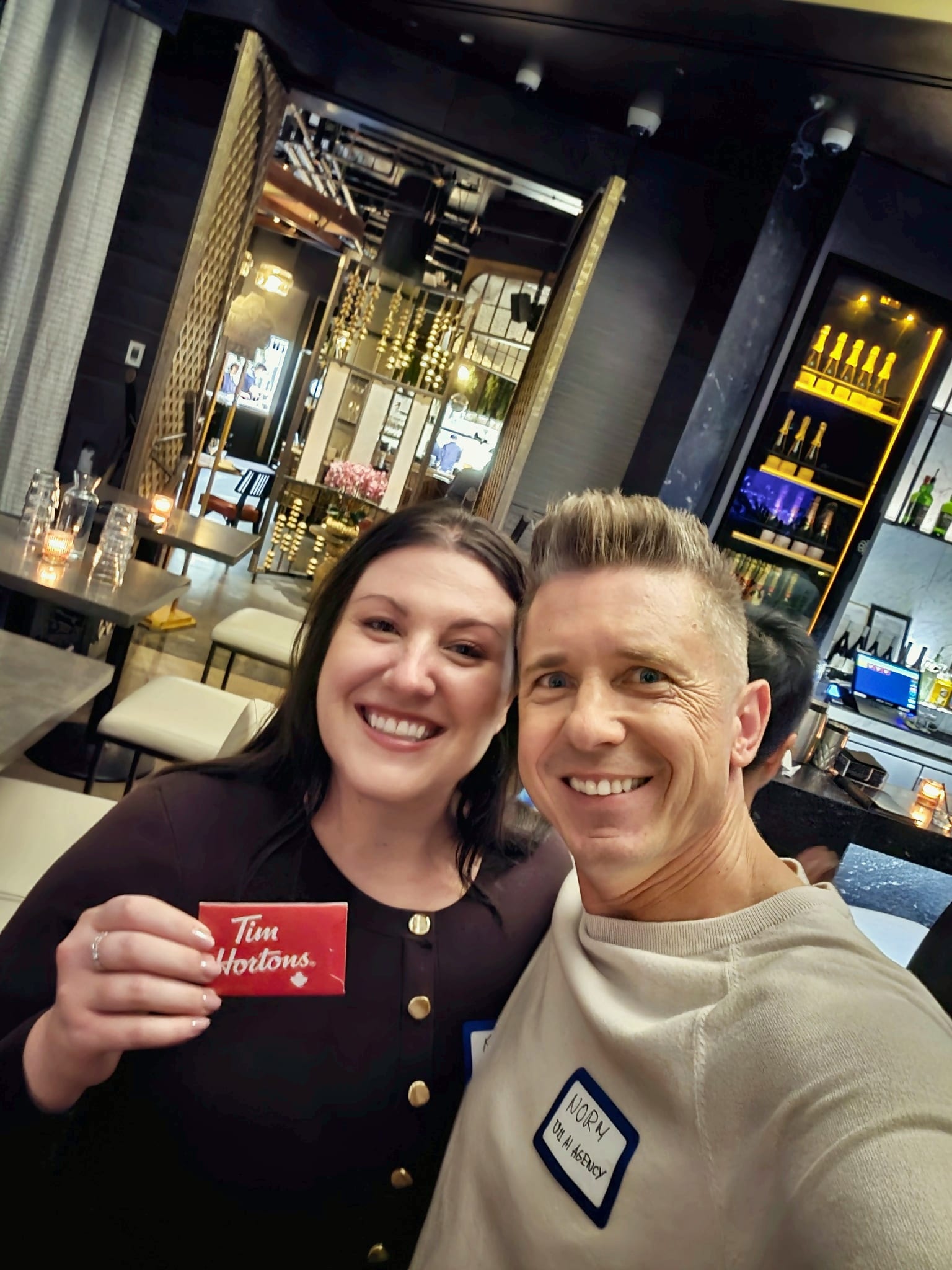 A guest holding a prize-draw gift card at the end of the networking night